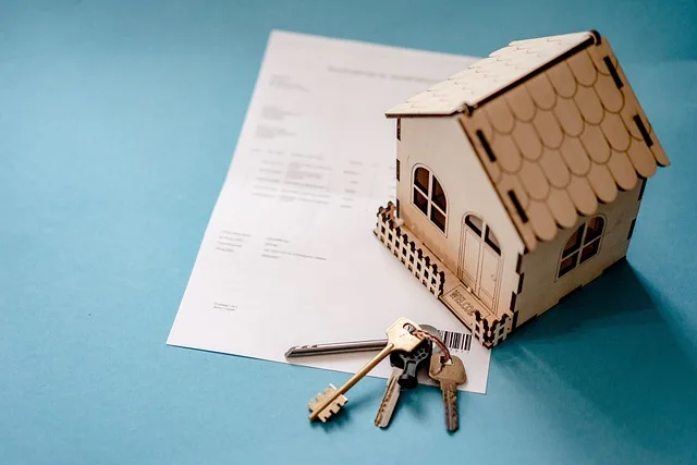 Immagine con sfondo blu un foglio di acquisti di una casa con sopra una casetta in cartone e delle chiavi